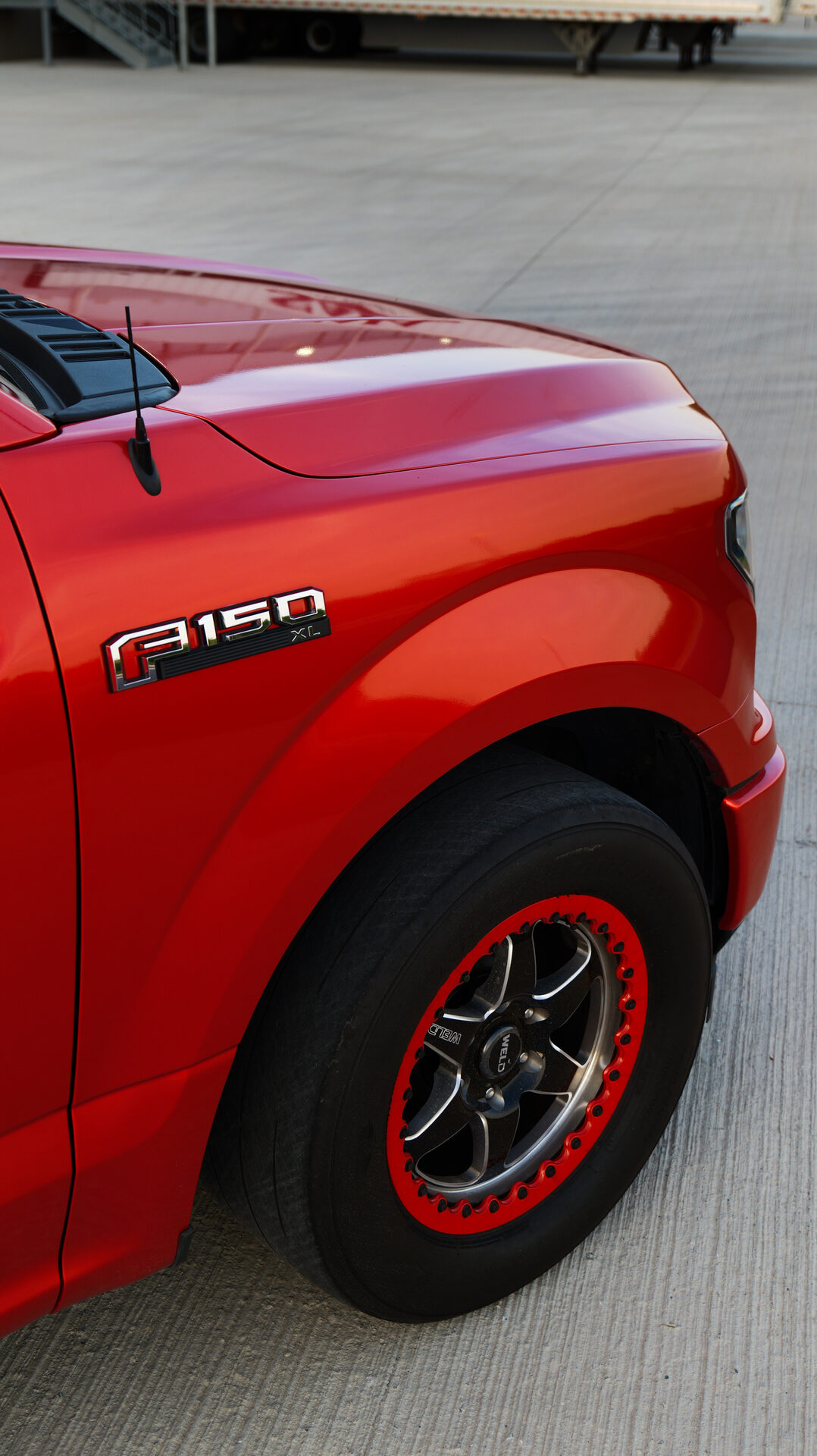 Close up of red truck fender and beadlock wheel